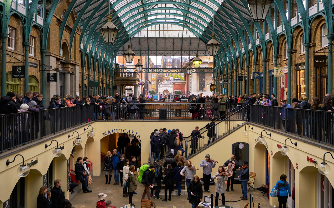 String quartet performing in the lower courtyard of Covent Garden market as crowds watch from the balcony above
