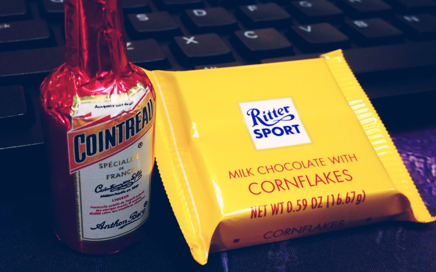 Ritter Sport milk chocolate bar with cornflakes next to a mini Cointreau liqueur bottle