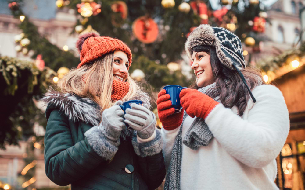 Festively decorated stalls at Les Halles Christmas Market in Place de la République, with visitors browsing artisanal crafts and enjoying traditional French treats