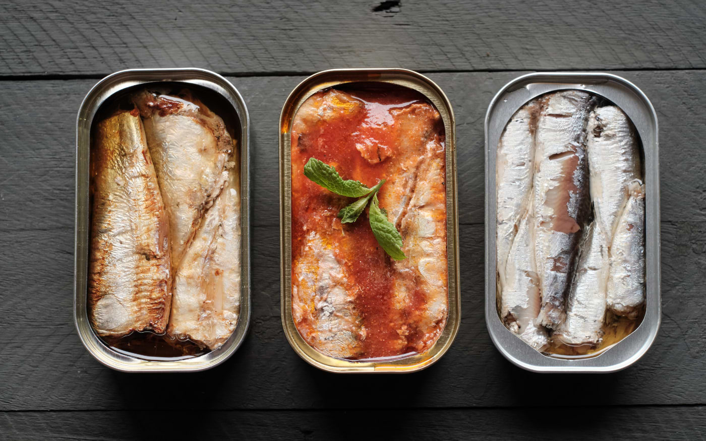 Three tins of Portuguese canned sardines in oil, tomato sauce and salt, a popular souvenir from Portugal.