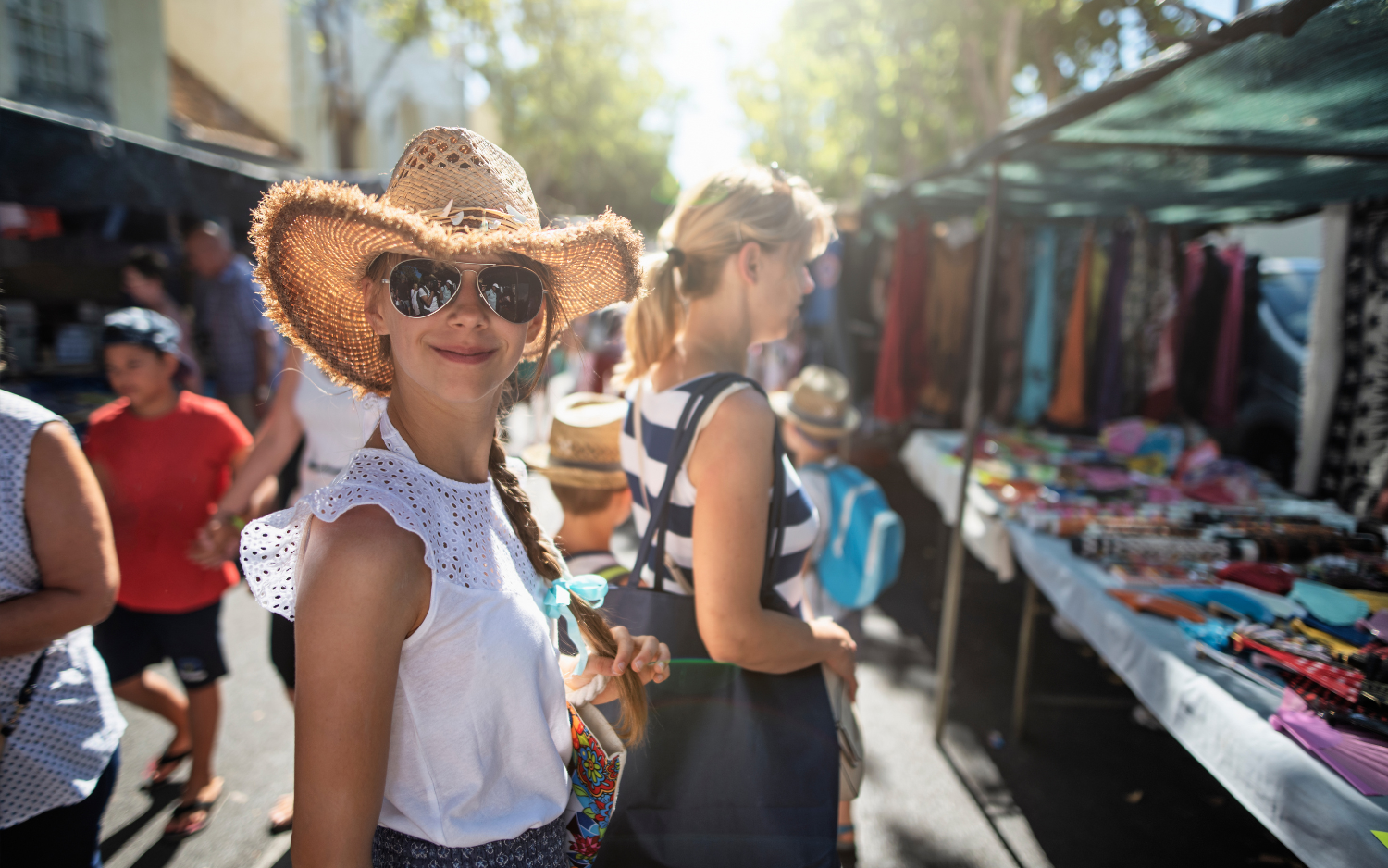 A woman browsing flea market stalls in Rome on a sunny day