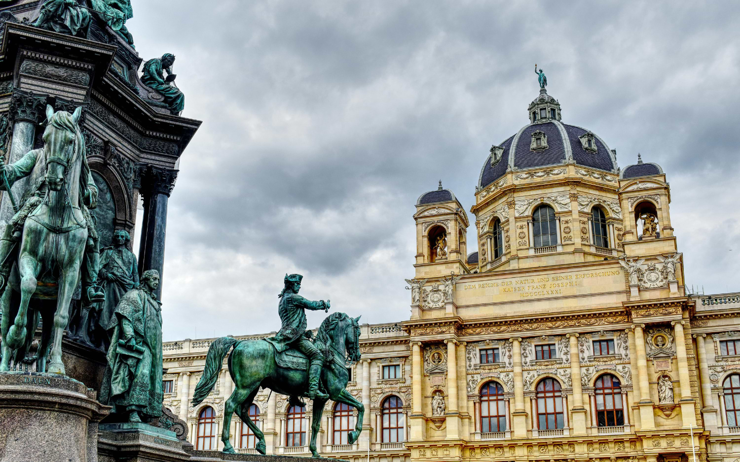 Kunsthistorisches Museum Vienna with its grand dome, seen behind bronze equestrian statues of the Maria Theresa Monument