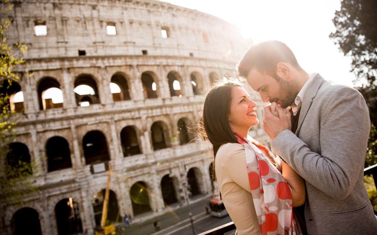 Romantic couple embracing in front of the Colosseum in Rome