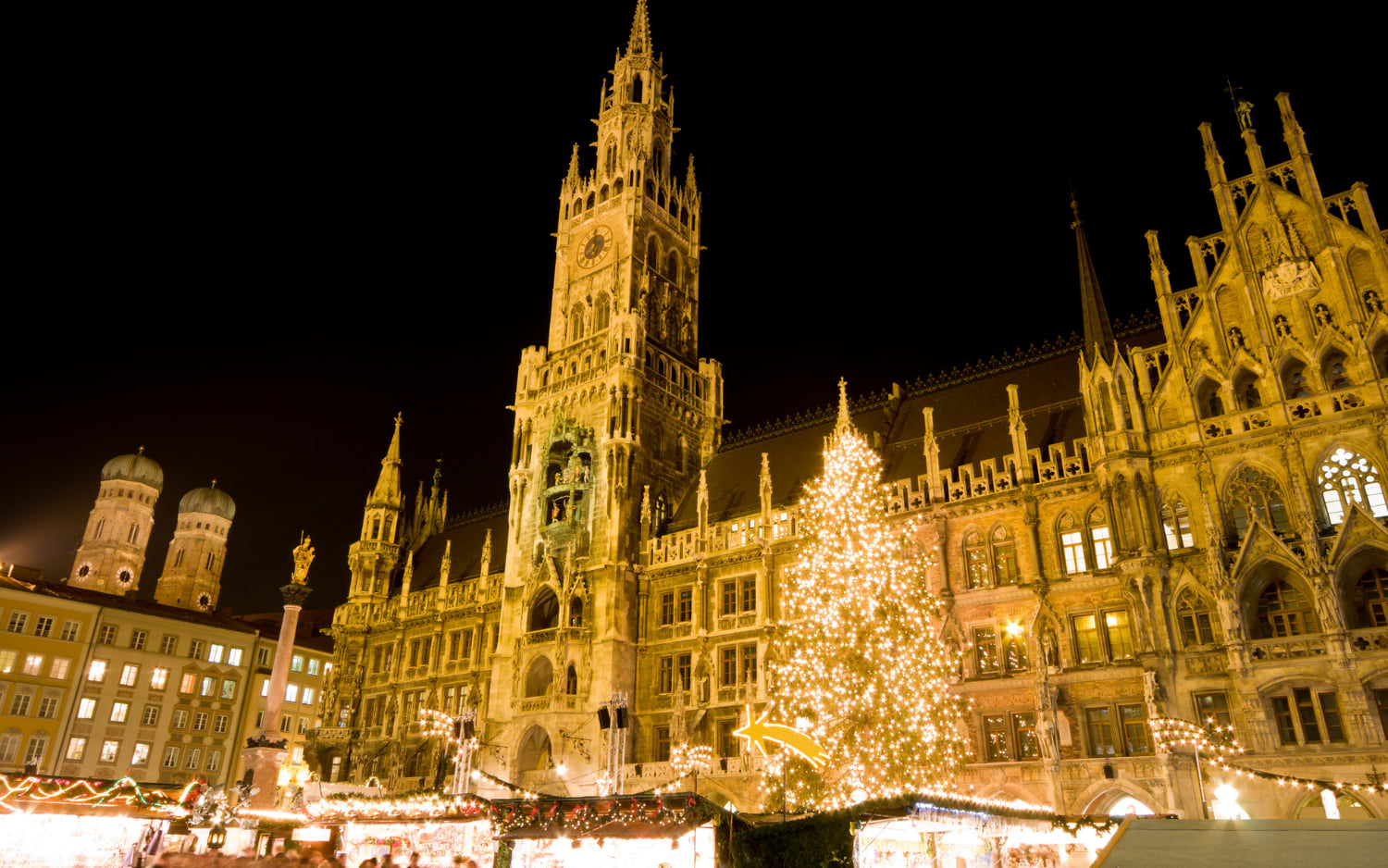 Christmas market at Munichās Marienplatz with a glowing Christmas tree before the New Town Hall and Frauenkirche towers