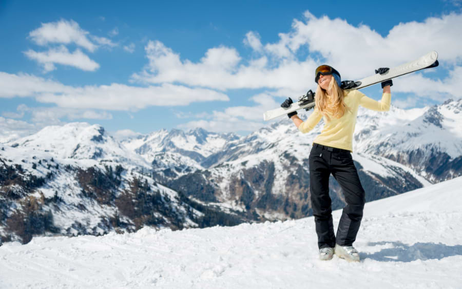 Skier enjoying the snow-covered slopes of Ski Amadé, surrounded by scenic Alpine landscapes under a clear blue sky