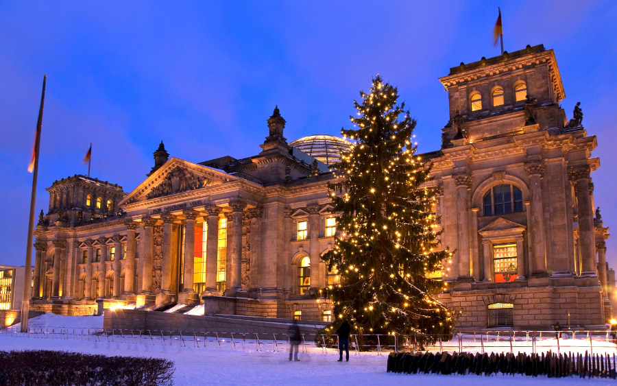 The illuminated glass dome of the Reichstag Building at night, offering panoramic views of Berlin's cityscape