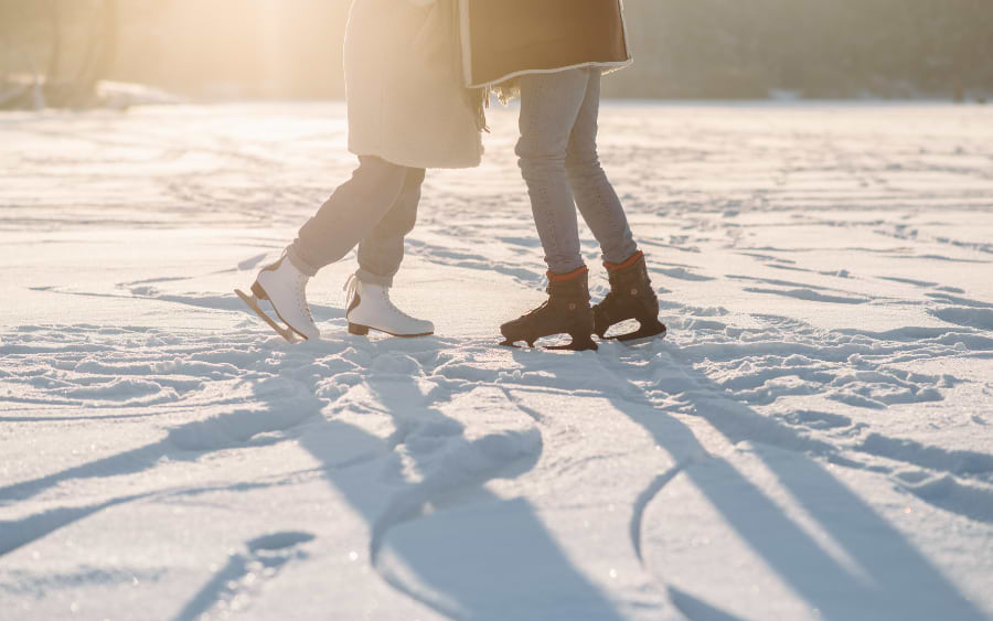 People ice skating on the illuminated outdoor rink of Wiener Eistraum at Rathausplatz