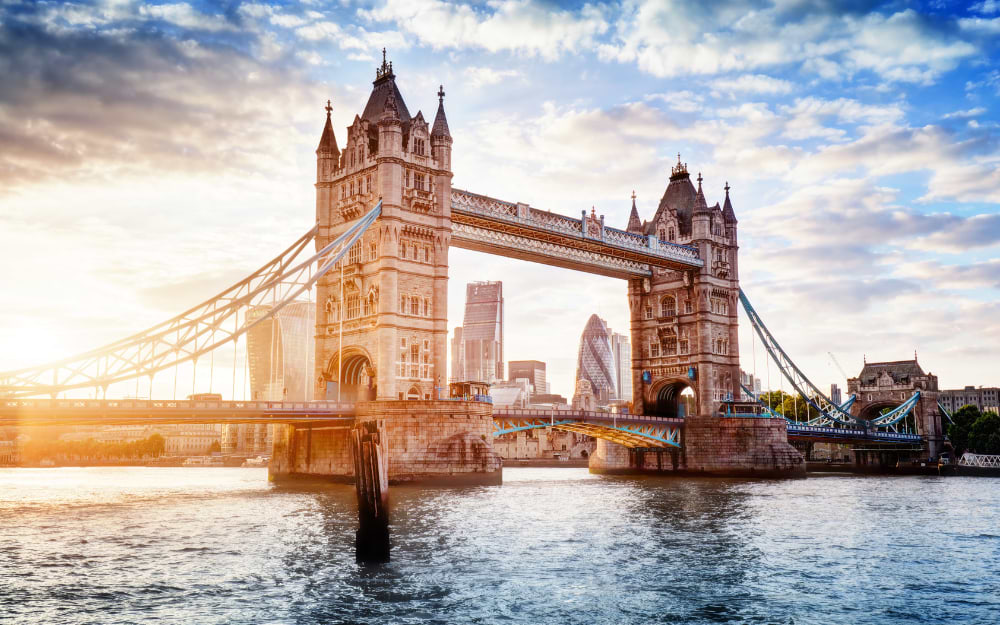 Tower Bridge over the River Thames at sunset, London skyline in background