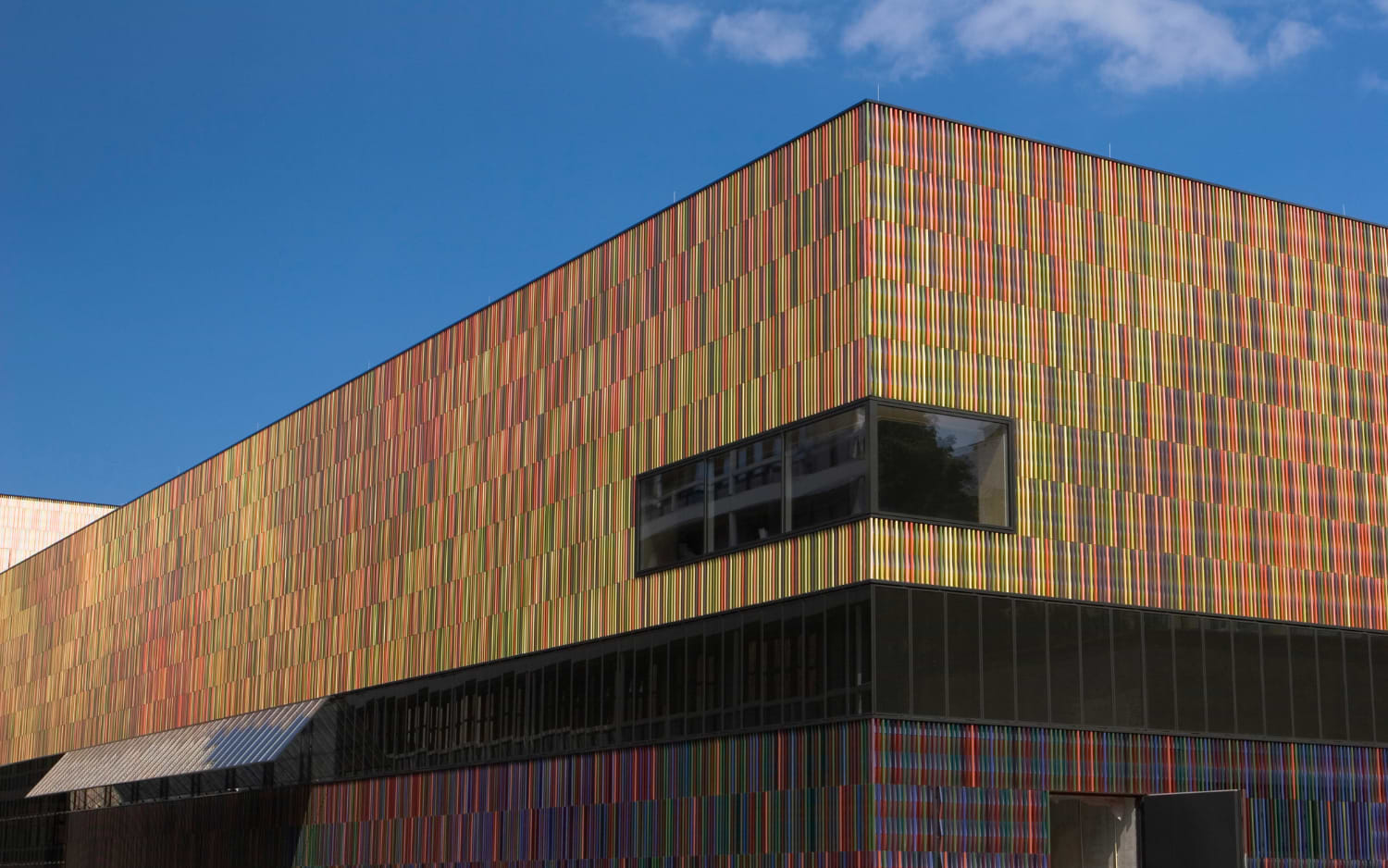 Close-up of Museum Brandhorst's striking facade in Munich, made from thousands of colourful vertical ceramic rods in the sunlight.