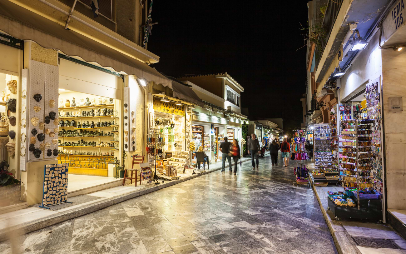 Illuminated souvenir and arts and crafts shops lining a quiet pedestrian street in the Plaka neighbourhood of Athens at night