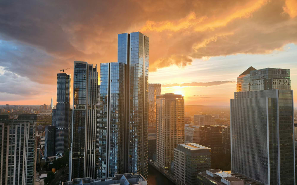 Canary Wharf skyscrapers at sunset with dramatic sky, East London