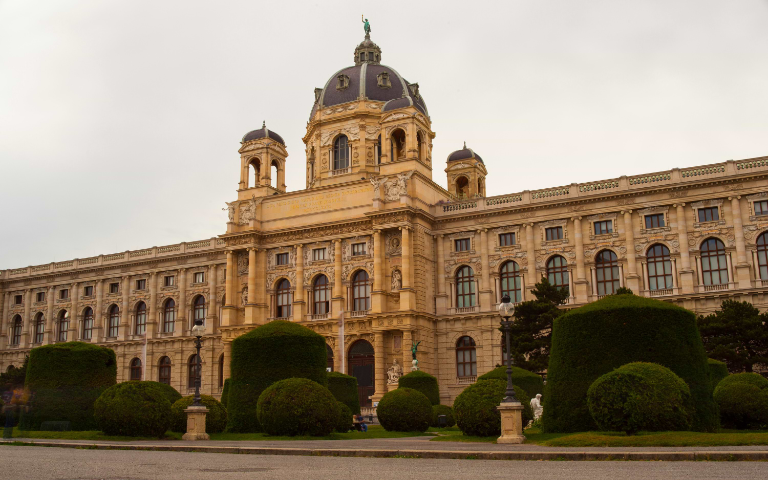 Naturhistorisches Museum Vienna, domed sandstone facade on Maria-Theresien-Platz behind neatly trimmed topiary