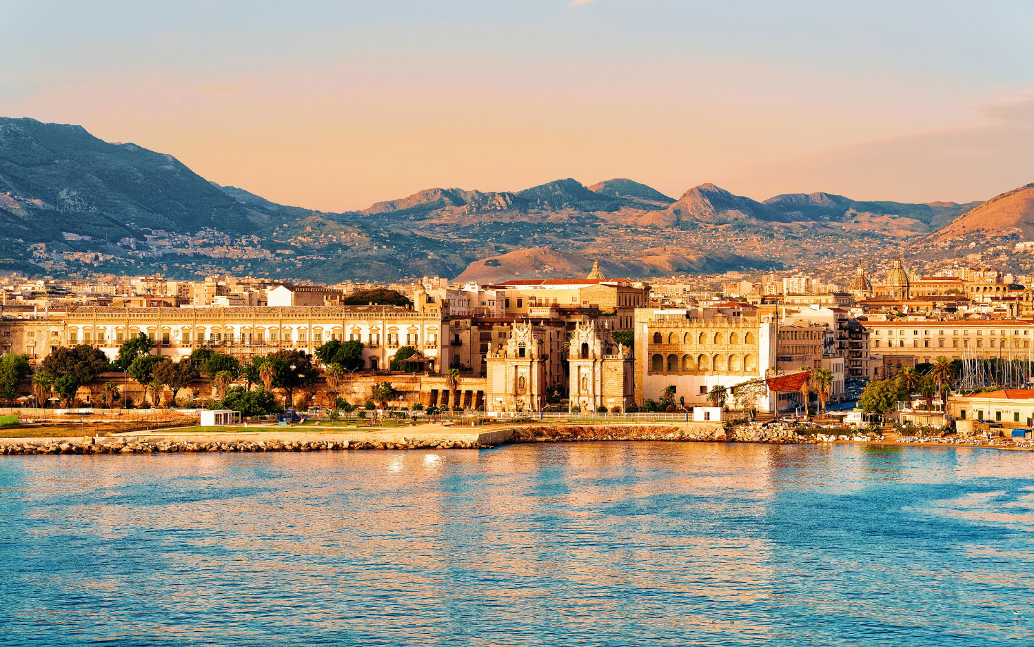 Palermos historische Uferpromenade im goldenen Abendlicht mit Bergen im Hintergrund
