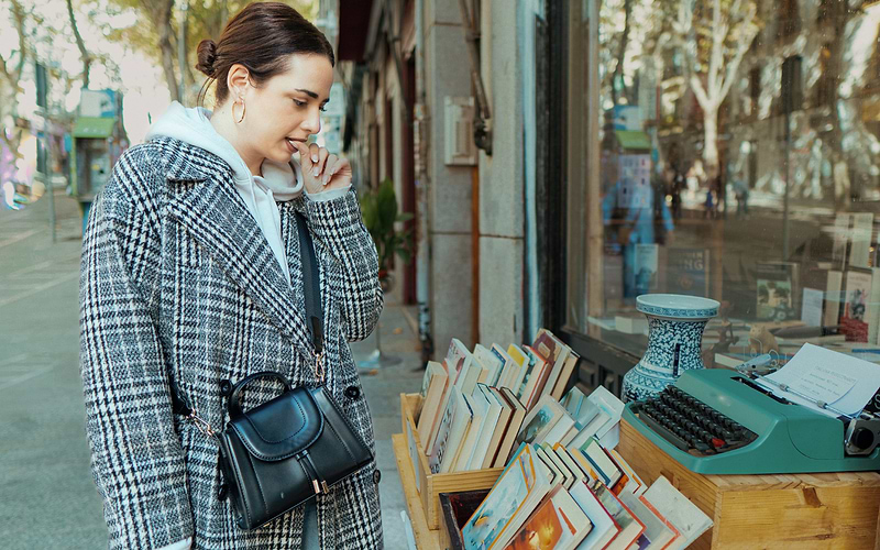 A woman browsing a flea market stall in Madrid, Spain