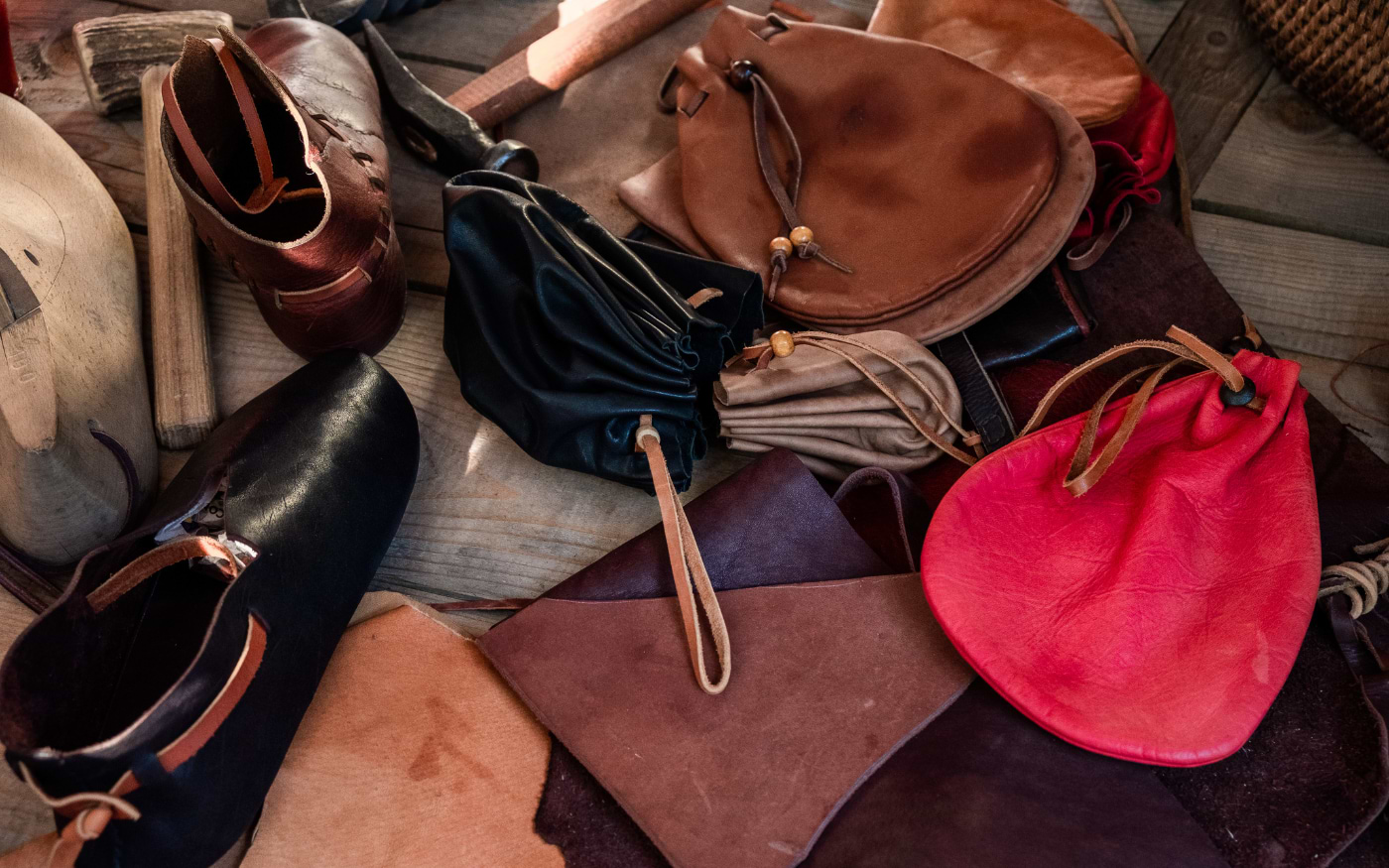 Handmade leather goods including pouches, shoes and bags, traditional Portuguese leather craftsmanship on display.