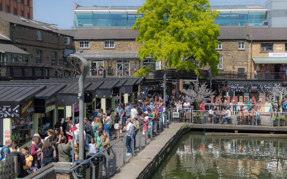 Crowds browsing Camden Market along the Regent's Canal on a sunny day in London