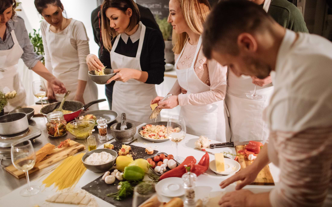 articipants in a Basque cuisine cooking class in Bilbao cooking together around a kitchen counter