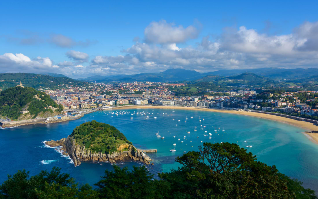 Aerial panoramic view of La Concha bay in San Sebastián with golden sandy beach and sailing boats