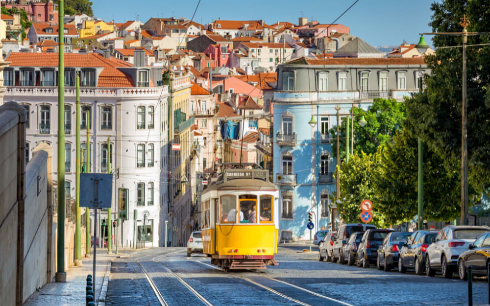 Narrow cobblestone streets in the Alfama district and the Tram 28, Lisbon, Portugal.