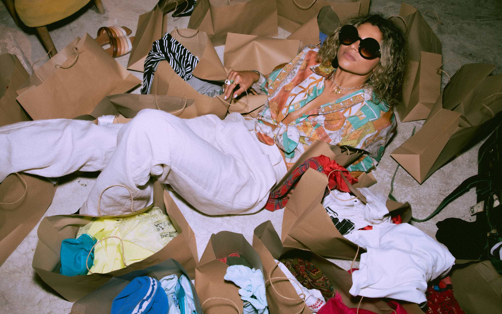 A seller at an Amsterdam flea market sitting on a pile of shopping bags