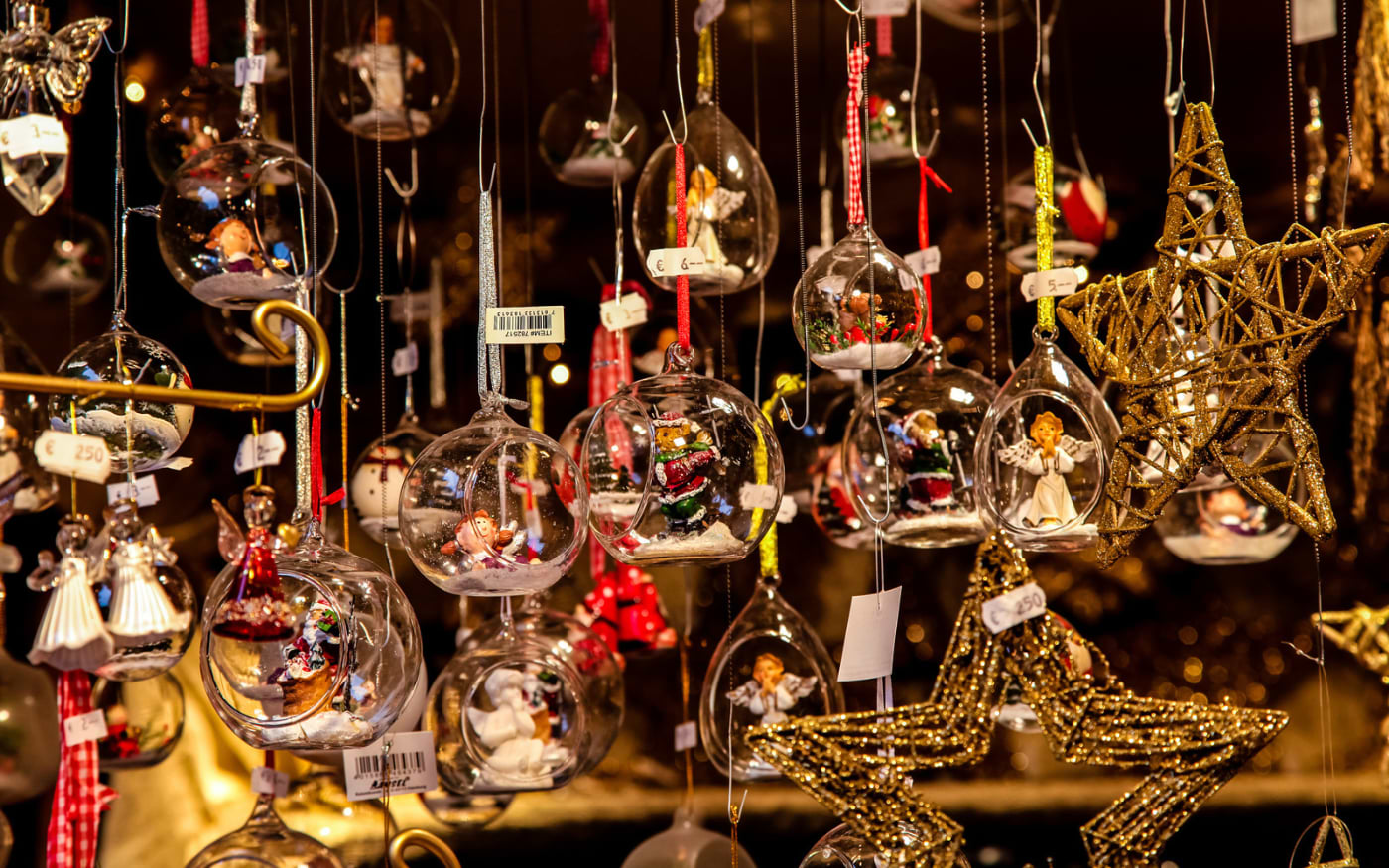 Glass Christmas baubles with angel and Santa figures and gold glitter stars hanging at a Munich Christmas market stall